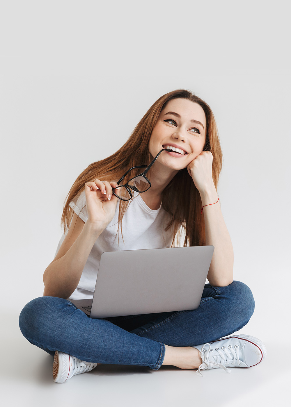 Smiling pensive woman in t-shirt sitting on the floor
